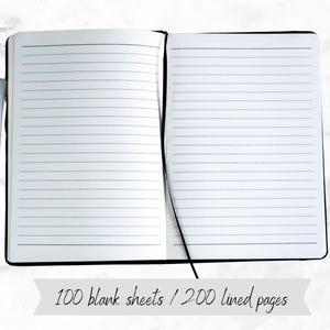 May include: A black lined notebook with a black ribbon bookmark. The notebook is open to reveal lined pages. The text "100 blank sheets / 200 lined pages" is visible below the notebook.