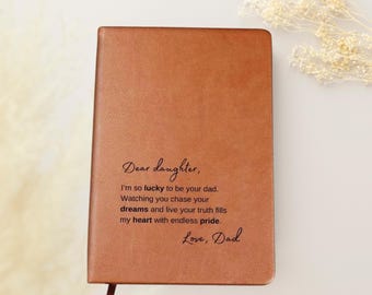 May include: A brown leather journal with a heartfelt message engraved on the front: "Dear daughter, I'm so lucky to be your dad. Watching you chase your dreams and live your truth fills my heart with endless pride. Love, Dad."