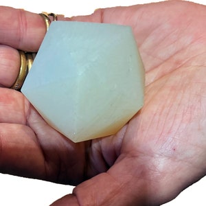Può includere: Un cristallo geometrico sfaccettato bianco translucido con una leggera tonalità gialla.