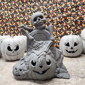 Ceramic Bisque Skeleton with Tombstone and Pumpkins Lamp. Light kit not included.
