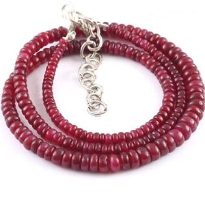 Op de afbeelding: Een rode edelsteen ketting met een zilveren sluiting. De ketting is gemaakt van kleine, ronde kralen.
