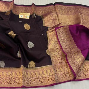 Rose and Orange Vasundhara Silk Saree, Majestically Detailed with Zari Buttas on Its Body, Highlighted by a Zari Border of Mayil, Diamond, and Vanki Designs, Richly Zari Detailed Pallu, and Paired with a Matching  Blouse