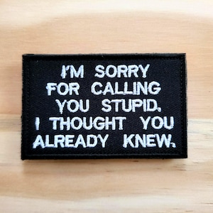 May include: Black embroidered patch with white text that reads: "I'M SORRY FOR CALLING YOU STUPID, I THOUGHT YOU ALREADY KNEW."