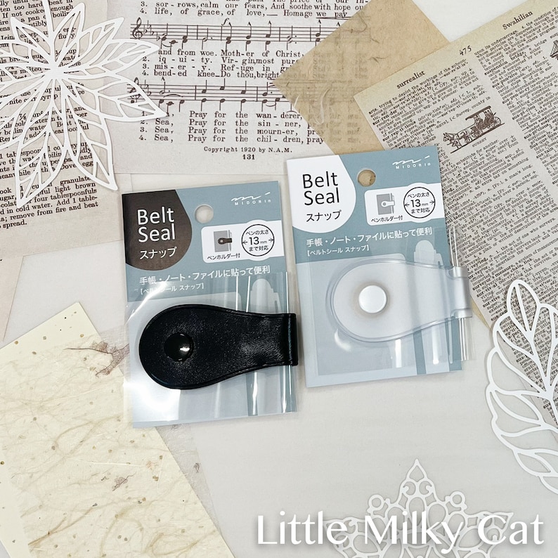 May include: Two packages of black and silver belt seals. The packages are labeled "Belt Seal" in Japanese and English. The seals are designed to hold notebooks, journals, and other items together.