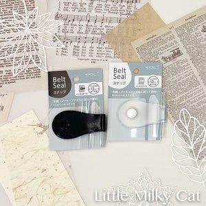 以下が含まれることがあります： 黒と白のテキストが書かれた透明なプラスチック製の包装カードが2枚。各カードには、黒と透明なプラスチック製のベルトシールが付属しています。カードのテキストには、「Belt Seal」と日本語で「スナップ」と書いてあります。カードのテキストには、日本語で「ペンホルダー付」とも書いてあり、これは「ペンホルダー付き」を意味します。カードのテキストには、日本語で「手帳・ノート・ファイルに貼って便利」とも書いてあり、これは「ノート、メモ帳、ファイルに貼り付けるのに便利です」を意味します。カードのテキストには、日本語で「ベルトシール スナップ」とも書いてあり、これは「ベルトシール スナップ」を意味します。