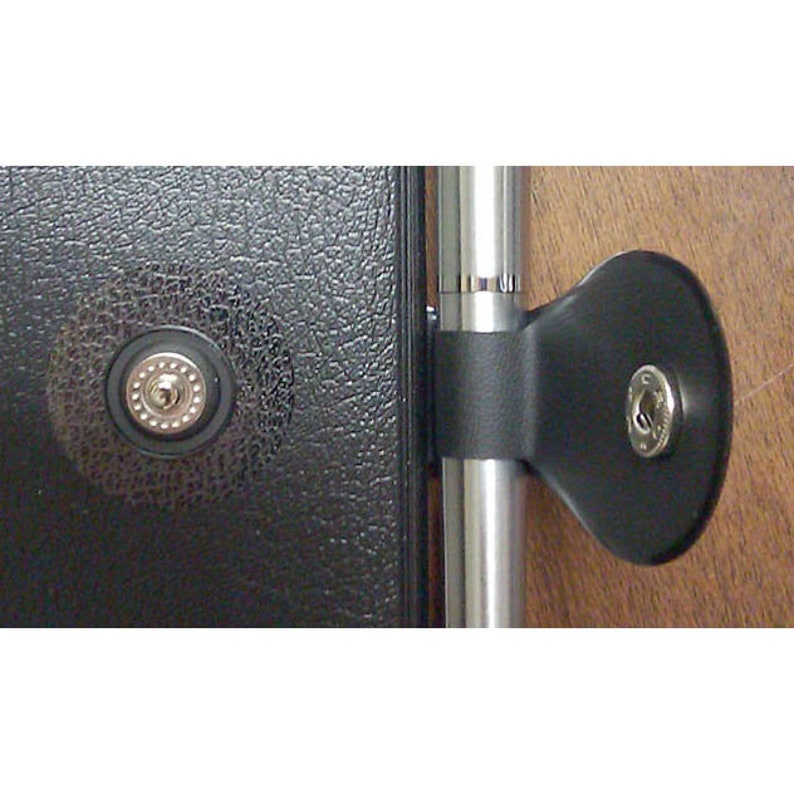 May include: A black leather-bound journal with a silver metal clasp and a silver pen holder. The journal has a textured surface and the pen holder is attached to the side of the journal.
