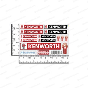 May include: A sheet of Kenworth decals in red, black, and white. The decals feature the Kenworth logo and text in various sizes and styles. A ruler is placed next to the decals for size reference.