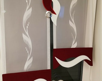 May include: Two white and burgundy window shades with decorative cutouts in the shape of a flame and a wave. The shades are pulled up and the window is visible behind them.