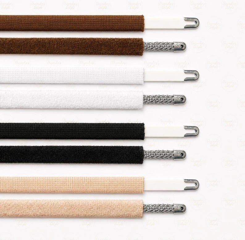 May include: Close-up of various shoelaces in brown, white, black, and beige. Each lace has a white plastic tip and a silver metal aglet. The laces are arranged horizontally against a white background.