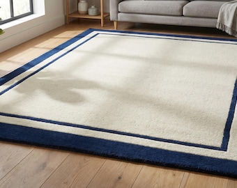 Alfombra grande de 8x10 pies para sala de estar con borde azul crema, ideal para la zona de sofás y sillones.