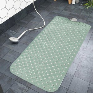 May include: A rectangular sage green bath mat featuring a repeating pattern of circular suction cups and small drainage holes across its entire surface, designed with rounded corners to fit securely within a standard shower or bathtub area.
