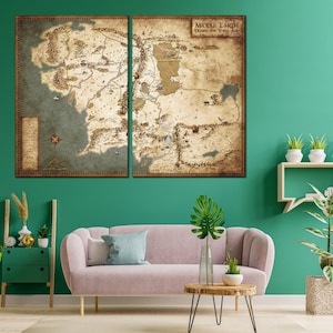 Pu&ograve; includere: Una mappa della Terra di Mezzo in stile vintage, divisa in due pannelli, con una legenda e il titolo "Middle-earth During the Third Age". La mappa &egrave; esposta su una parete verde sopra un divano rosa e un tavolino da caff&egrave; in legno.