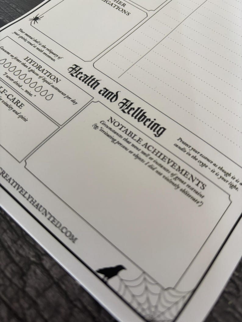 K&ouml;nnte beinhalten: Ein wei&szlig;er Papierplaner mit schwarzem Text und Illustrationen. Der Planer enth&auml;lt Abschnitte f&uuml;r "Gesundheit und Wohlbefinden" und "Andere Ermittlungen". Eine Spinne und eine Kr&auml;he sind im Design enthalten. Die Website creativelyhaunted.com ist unten aufgedruckt.