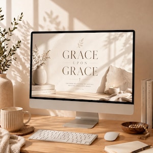 K&ouml;nnte beinhalten: Ein Computer zeigt den Text "GRACE UPON GRACE" mit einem Kreuz und einem Bibelvers. Eine Tasse, eine Tastatur, eine Maus und ein Notizbuch mit einem Stift befinden sich auf dem Holzschreibtisch. Eine Vase mit Blumen und B&uuml;cher sind ebenfalls vorhanden.
