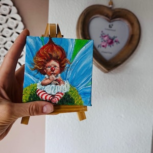 Mini pintura de hada payaso. Pelirroja caprichosa con alas. Arte acrílico original sobre lienzo. Miniatura de 10 x 10 cm. Coleccionable con caballete. Firmada por