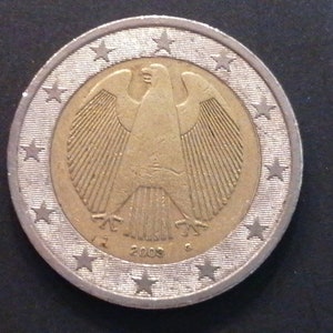 Könnte beinhalten: Eine silberne und goldfarbene 1-Euro-Münze mit einem deutschen Adler-Design. Die Münze hat 12 Sterne am Rand und das Jahr 2003 ist unten aufgedruckt.