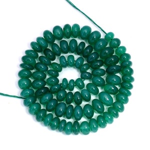 May include: A strand of green gemstone beads, likely agate, arranged in a circle. The beads are oval-shaped and have a smooth, polished finish.
