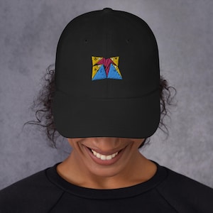 May include: Black baseball cap with a colourful embroidered design. The design features a geometric shape with red, blue, and yellow colours. The cap has a curved brim and a classic six-panel construction.