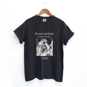 May include: Black t-shirt with a white print of a book cover for "Romeo and Juliet" by William Shakespeare. The cover features a black and white illustration of two people embracing. The text "London 1591 - 1596" is printed below the illustration.