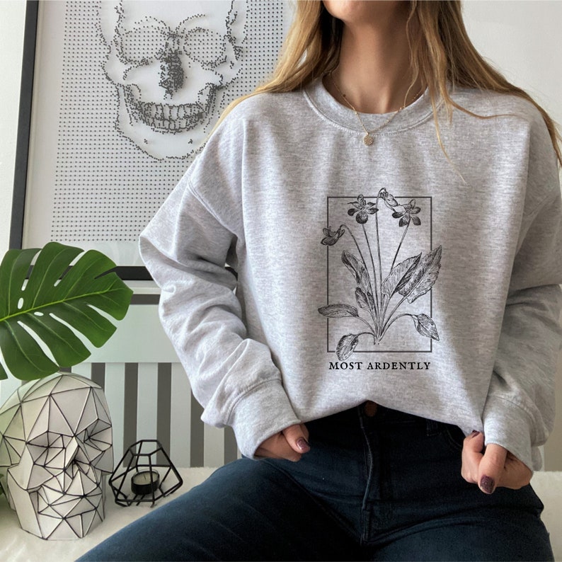 May include: Gray sweatshirt with a black and white illustration of a flower and the text "MOST ARDENTLY".