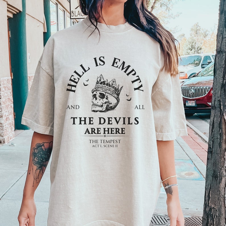 May include: A beige t-shirt with a black graphic print that reads "Hell is empty and all the devils are here. The Tempest Act 1, Scene II". The graphic also includes a skull wearing a crown.