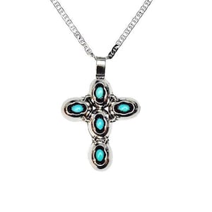 May include: A silver-toned metal cross pendant suspended from a matching link chain. The cross features five oval-shaped, bright turquoise-coloured stones set into the metal frame, with one stone at each end and one in the centre.