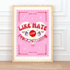 May include: A framed pink poster with the text "LIKE MATE STOP Procrastinating" in a heart shape. The poster also includes the text "BANG CHAN" and "STRAY KIDS". The poster has a light wood frame.