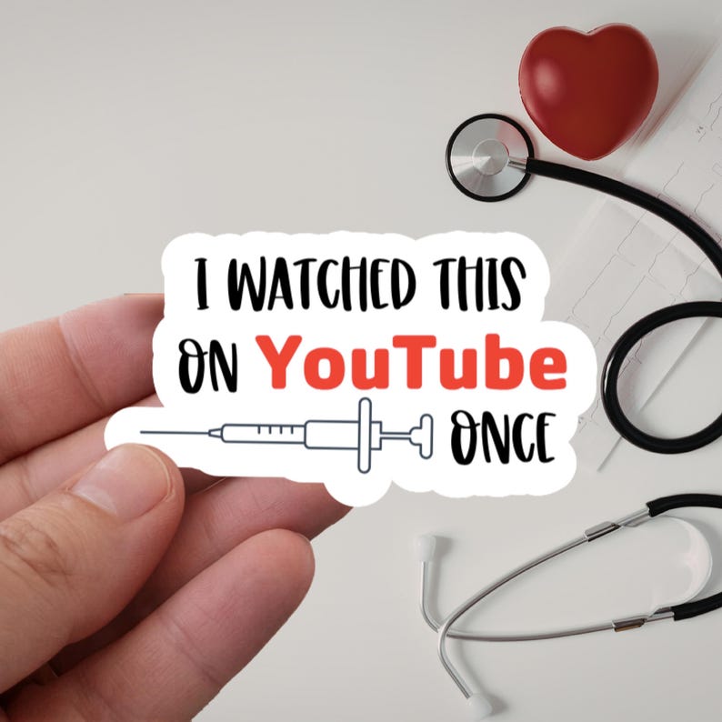 Puede incluir: Una pegatina blanca con el texto "I WATCHED THIS ON YouTube ONCE" en negro y rojo. Tambi&eacute;n presenta un gr&aacute;fico de jeringa. Un coraz&oacute;n rojo y un estetoscopio se ven en el fondo.