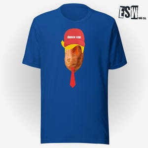 May include: A royal blue t-shirt featuring a graphic of a sweet potato wearing a red "dunce cap" and a red tie. The text on the cap reads "dunce cap".