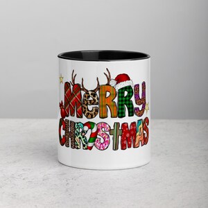 May include: White ceramic mug with a black rim and handle. The mug features a colorful patchwork design that spells out "Merry Christmas".