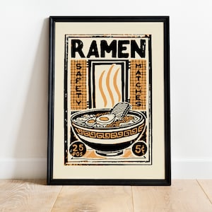 Pode incluir: Um cartaz de estilo vintage com uma moldura preta a anunciar "Ramen" com uma tigela de macarr&atilde;o ramen, um ovo e um peda&ccedil;o de carne. O cartaz tem um esquema de cores amarelo e preto e diz "Safety Matches" e "25 Pcs 5&cent;".