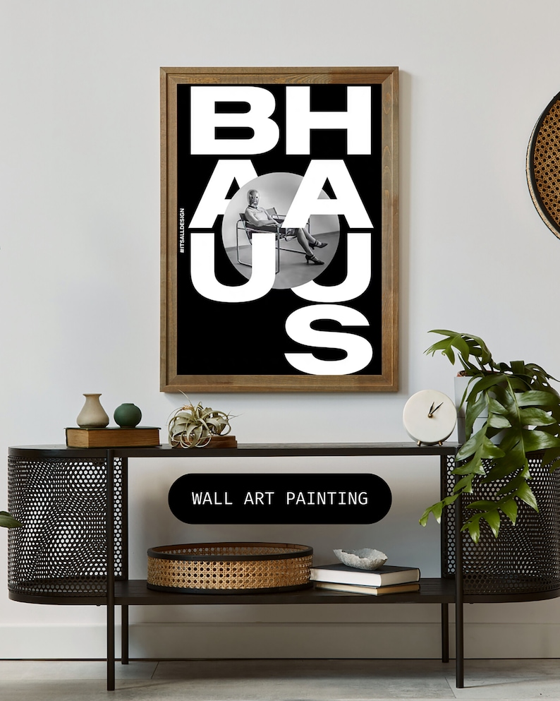 May include: Black and white wall art painting with the word "BAHAUS" in large white letters. The letters are overlapping and a person is sitting in a chair in the middle of the word.
