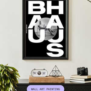 May include: Black and white wall art painting with the word "BAHAUS" in bold white letters. A black and white photo of a person sitting in a chair is visible through the letters.