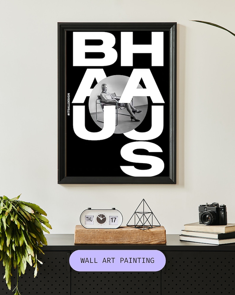 May include: Black and white wall art painting with the word "BAHAUS" in bold white letters. A black and white photo of a person sitting in a chair is visible through the letters.