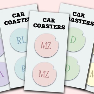 May include: Four sets of car coasters with different initials. The coasters are round and have a cut-out for a cup. The initials are A, RL, MZ, and D. The coasters are in different colors: purple, light blue, pink, and green.