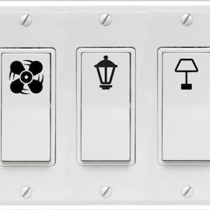 May include: White light switch plate with three toggle switches. The left switch has a fan icon, the middle switch has a streetlight icon, and the right switch has a table lamp icon.