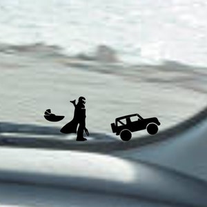Puede incluir: Una silueta negra de un personaje de Star Wars, Darth Vader, sosteniendo un bebé en una cápsula, caminando hacia una silueta negra de un Jeep. La imagen es una pegatina para la ventana de un coche.