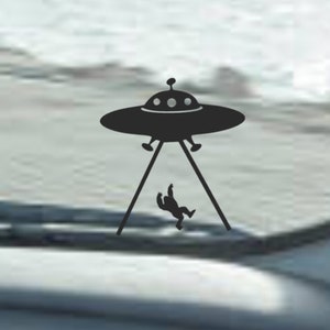 Könnte beinhalten: Eine schwarz-weiße Silhouette eines UFOs, aus dem eine Person fällt. Das UFO hat drei runde Lichter oben.