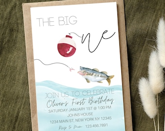 Può includere: Un invito ad acquerello blu e bianco con un galleggiante da pesca rosso e bianco e un pesce. Il testo recita "The Big One" e "Join us to celebrate Oliver's First Birthday, Saturday January 1st @ 1:00 PM, Johns House, 1234 Main St, New York NY 12345, Rsvp to Mom 123.456.7891".