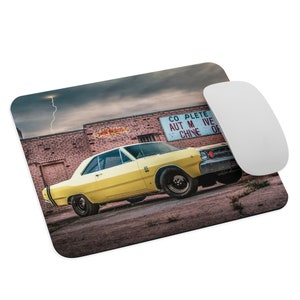 May include: A yellow 1968 Dodge Dart with black racing stripes parked in front of a brick building with a sign that reads "Complete Automotive Machine Shop".