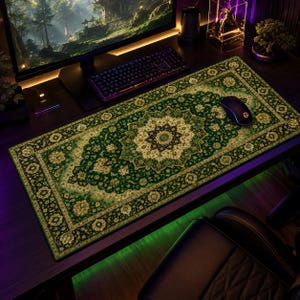 Può includere: Un tappetino da scrivania rettangolare caratterizzato da un intricato motivo a tappeto in stile persiano tradizionale, nei toni del verde bosco intenso, crema e nero. Il design presenta un medaglione floreale centrale circondato da motivi botanici.