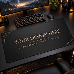 May include: A rectangular black desk mat featuring a subtle grid pattern and gold-coloured text that reads YOUR DESIGN HERE, UPLOAD ANY IMAGE, LOGO, PHOTO, TEXT. The mat has rounded corners and gold-coloured curved lines framing the central area.