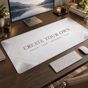 Peut inclure: Un tapis de bureau rectangulaire avec un motif géométrique blanc et gris clair. Le centre présente le texte noir "CREATE YOUR OWN" suivi de "PHOTO • LOGO • ARTWORK • TEXT". Le tapis a une surface lisse et est posé sur un bureau en bois sombre.