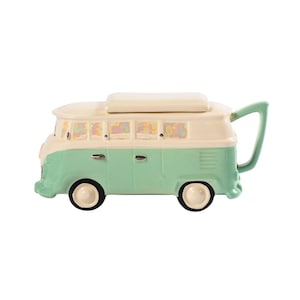 May include: A green and white ceramic teapot shaped like a vintage Volkswagen van. The teapot has a removable lid and a spout on the side.