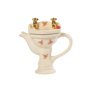 May include: A white ceramic teapot shaped like a pedestal sink with gold taps and pink floral accents.