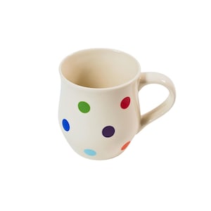 Puede incluir: Una taza de cerámica blanca con un patrón de lunares en varios colores, incluyendo rojo, azul, verde y naranja.