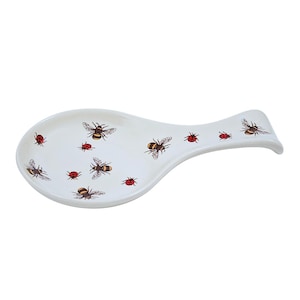 May include: White ceramic spoon rest with a bee and ladybug design.