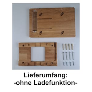 May include: A wooden wall mount for a tablet or phone. The mount is made of light brown wood and has a rectangular cutout for the device. The mount comes with screws and anchors for installation. The text "Lieferumfang: -ohne Ladefunktion- " is visible in the image.