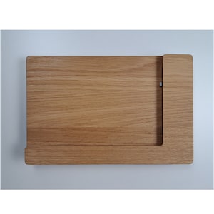 Könnte beinhalten: Ein Schneidebrett aus Holz mit integriertem Messerhalter. Das Brett ist aus hellbraunem Holz und hat eine glatte Oberfläche.