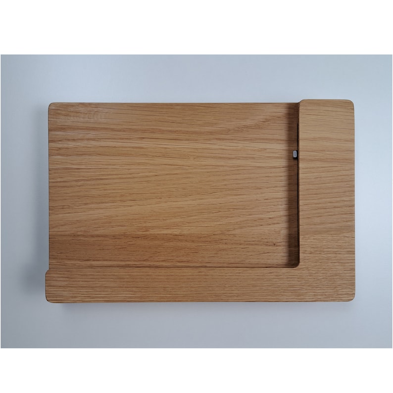 May include: A wooden cutting board with a built-in knife holder. The board is made of light brown wood and has a smooth surface.